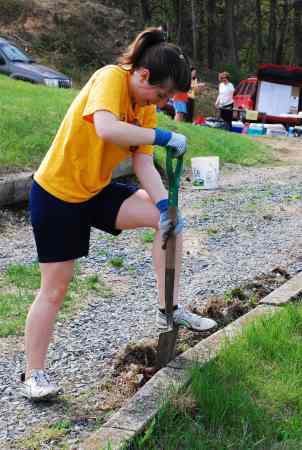 Volunteer Zoe restores a clean edge to an overgrown walkway. (Photo Courtesy of Dana Grubb)